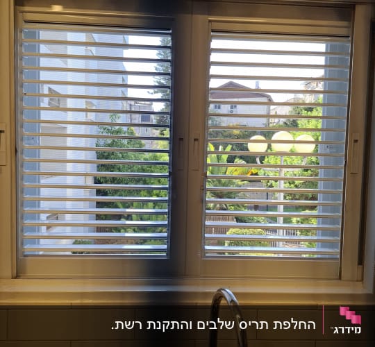 חלון אלומיניום עם סורגים שקופים מותקנים מעל כיור מטבח